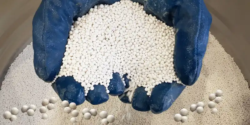 Activated alumina beads held in gloved hands - an efficient type of desiccant.